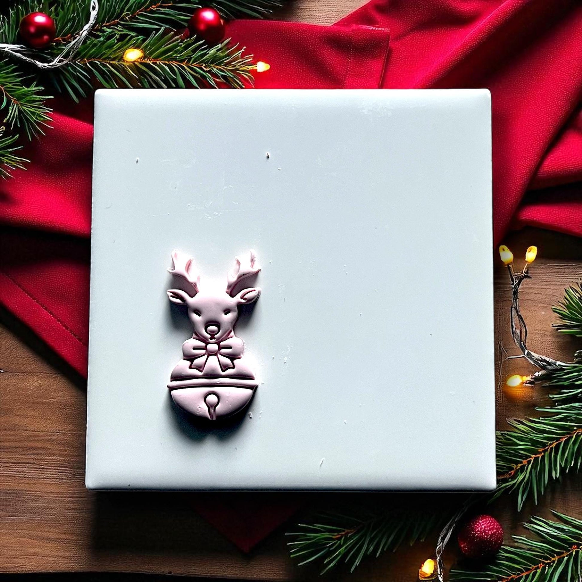Reindeer polymer clay cutter on white tile with red fabric and lights