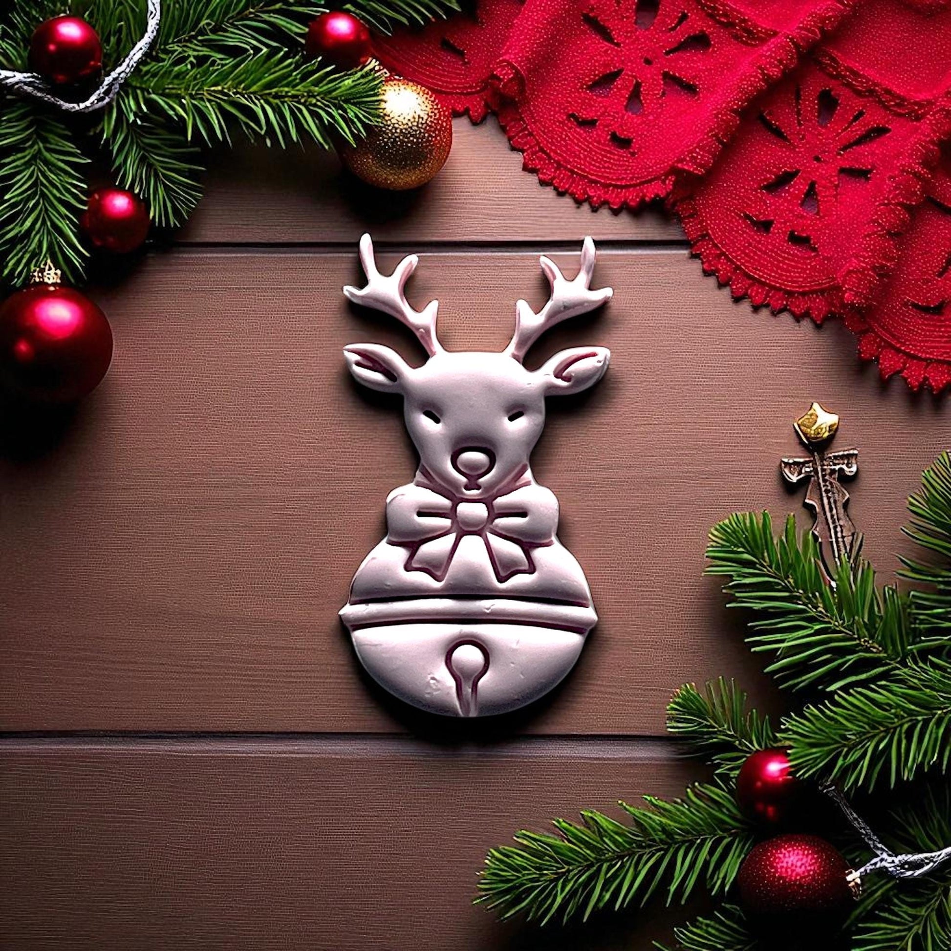 Reindeer clay imprint beside red cutter on holiday background