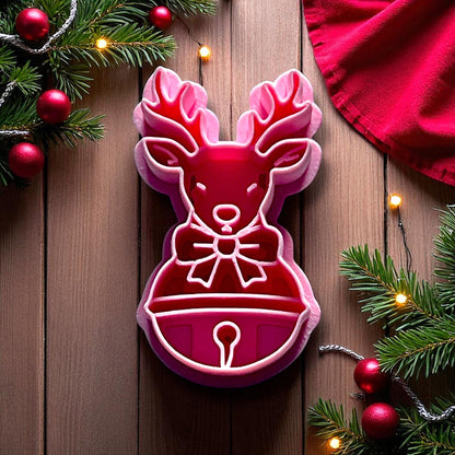 Reindeer clay imprint with antlers, bow, and bell on pink clay slab