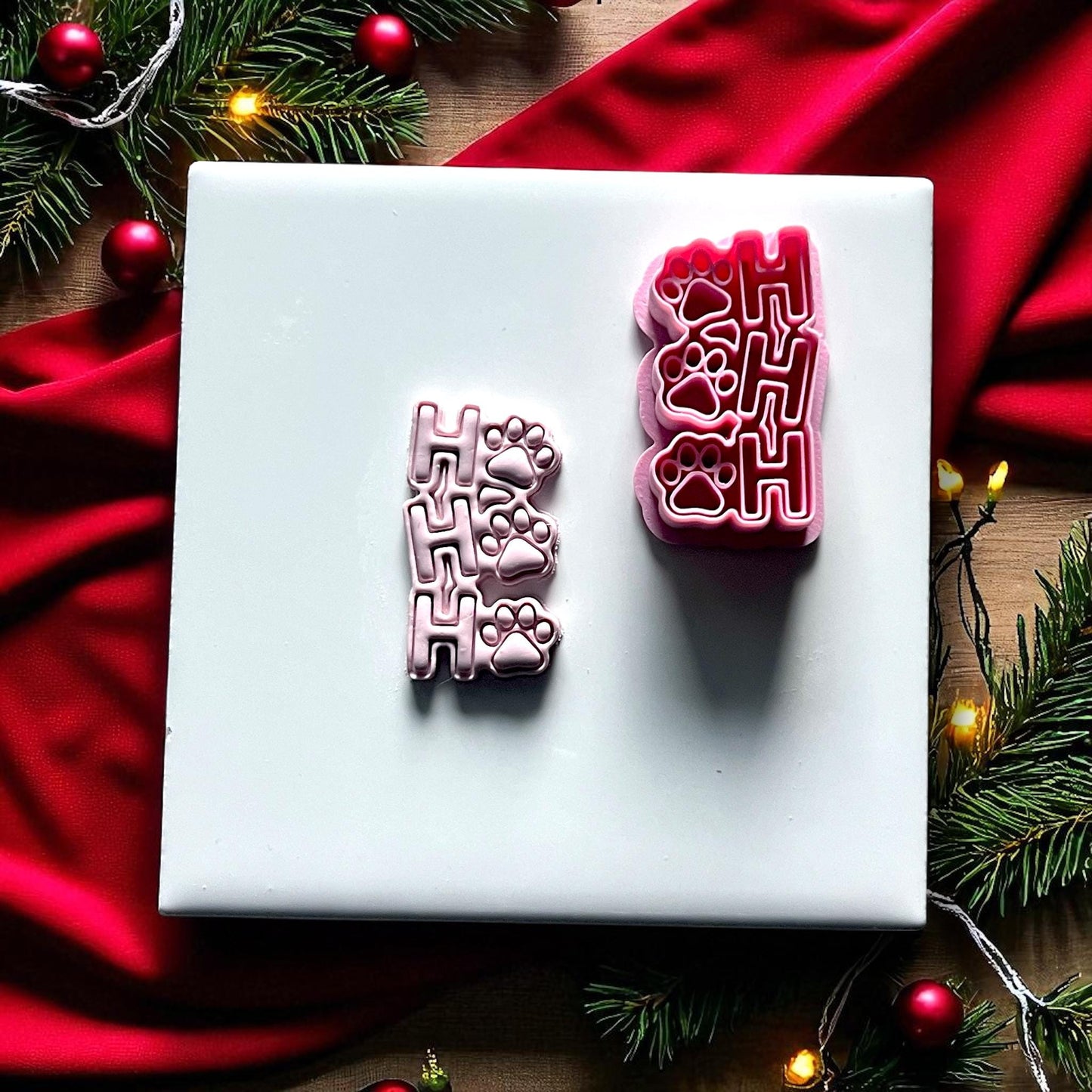 Ho Ho Ho paw print clay imprint and cutter on white tile with red fabric