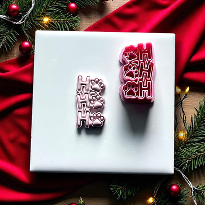 Ho Ho Ho paw print clay imprint and cutter on white tile with red fabric