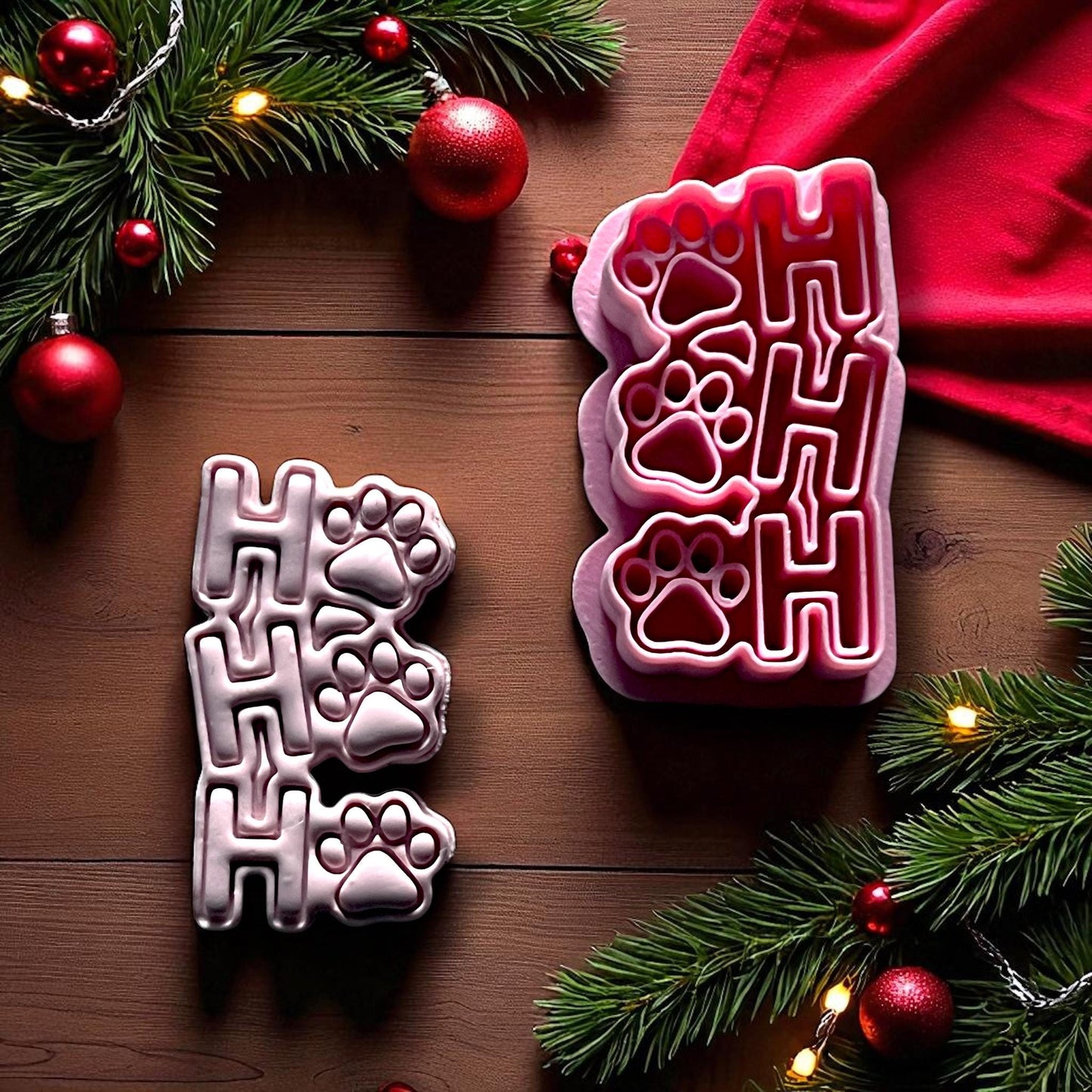 Ho Ho Ho paw print clay imprint beside red cutter on wood background