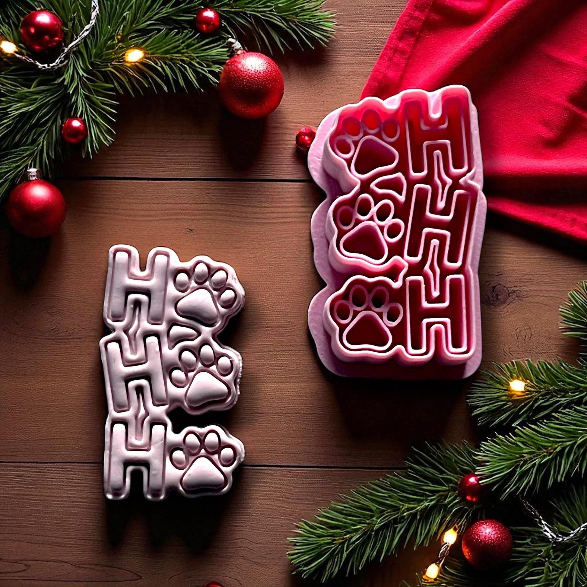 Ho Ho Ho paw print clay imprint beside red cutter on wood background