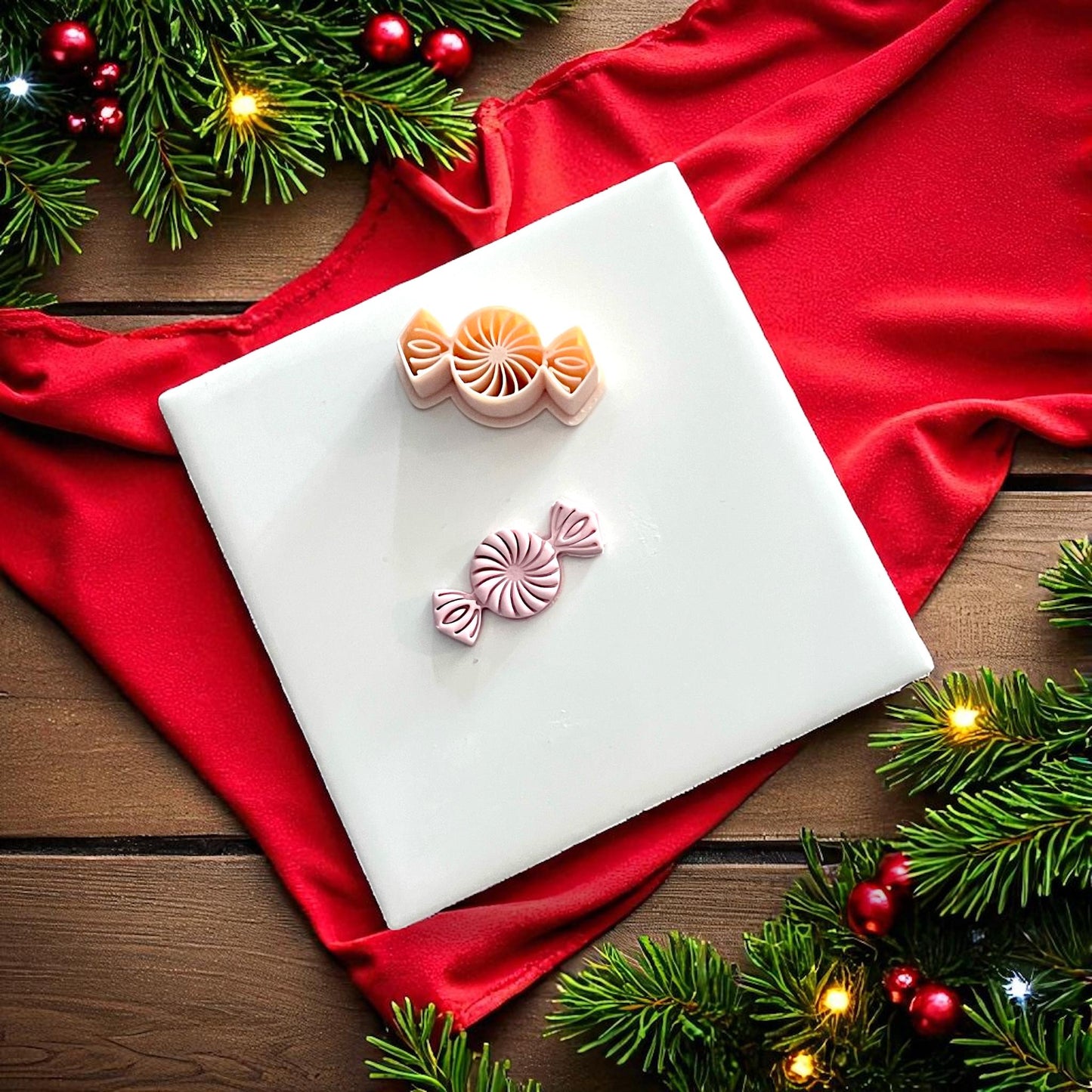 Peppermint candy clay imprint and cutter on white tile with red fabric and greenery