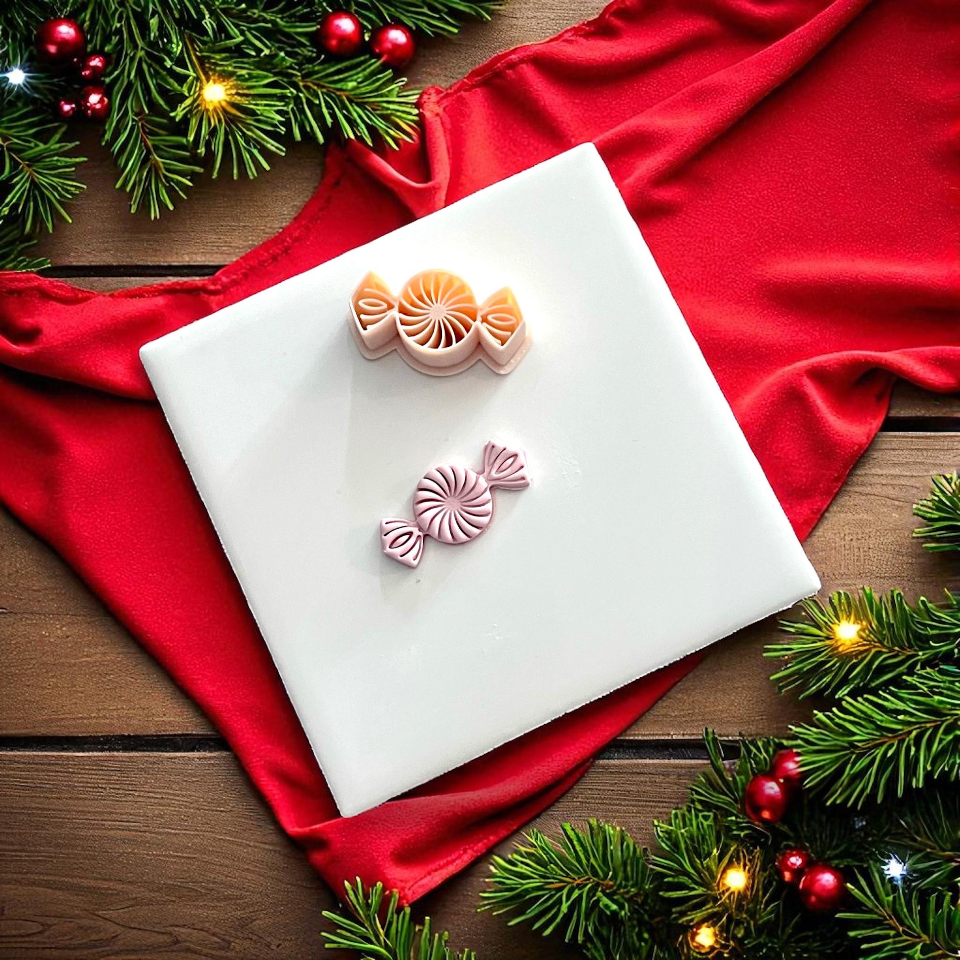 Peppermint candy clay imprint and cutter on white tile with red fabric and greenery