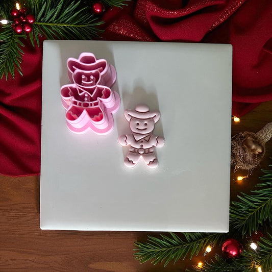 Cowboy gingerbread man cutter and imprint side by side on white tile