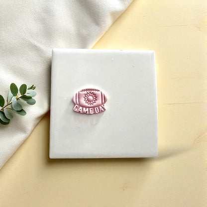 Small sunflower football game day clay imprint on white tile