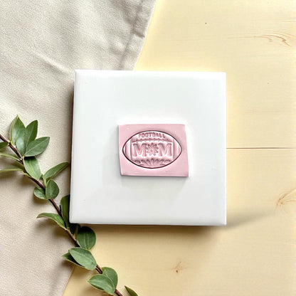 Football mom polymer clay imprint on white tile with greenery