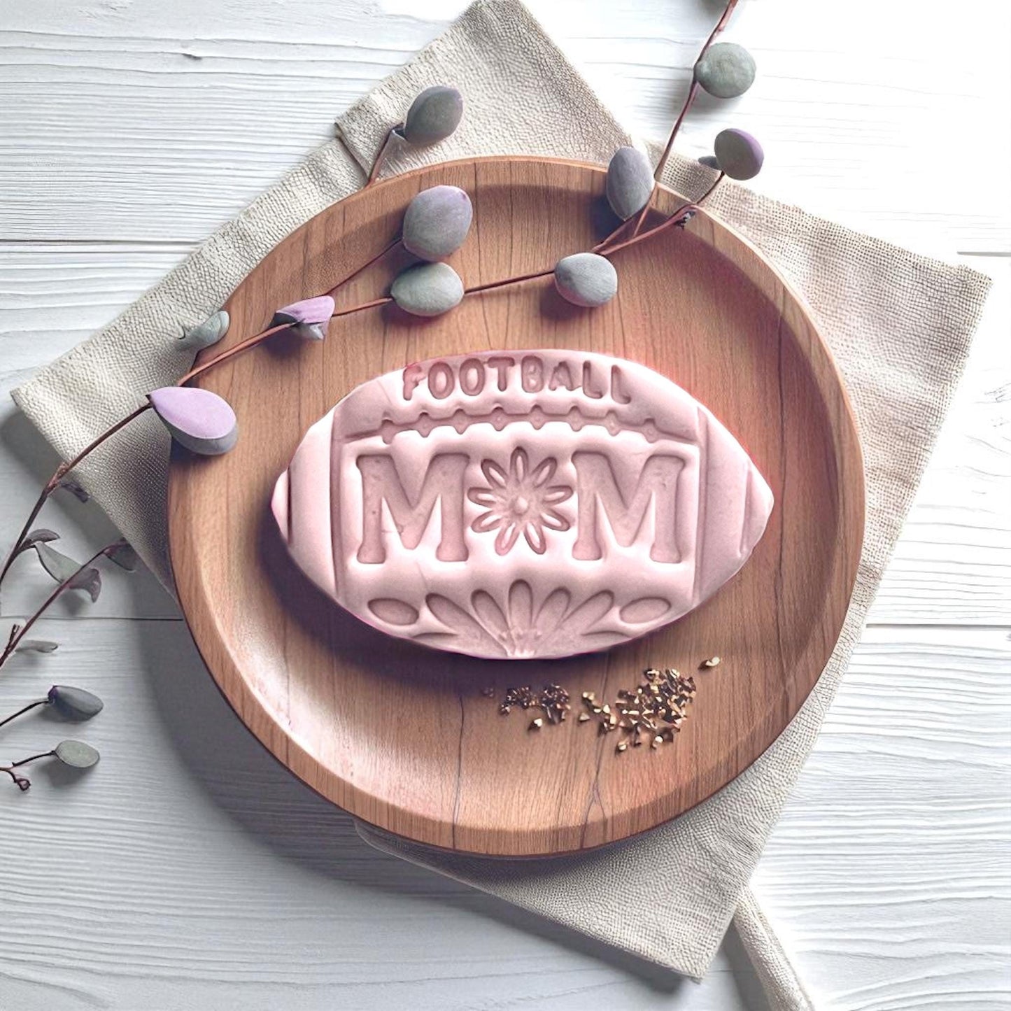 Football mom floral clay imprint displayed on wood plate with leaves