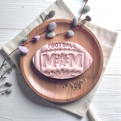 Football mom floral clay imprint displayed on wood plate with leaves