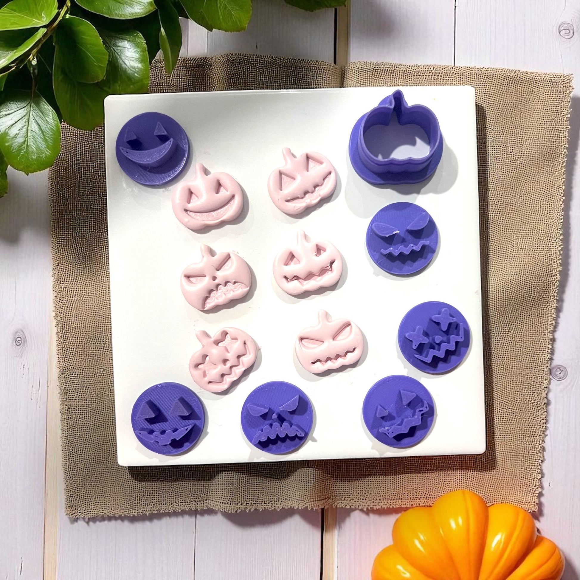Purple and pink pumpkin face cutters and shapes on white tile