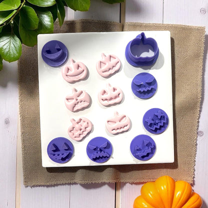 Purple and pink pumpkin face cutters and shapes on white tile