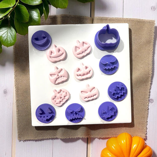 Purple and pink pumpkin face cutters and shapes on white tile