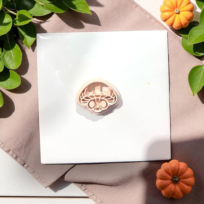 Mushroom skull clay cutter on white tile with pumpkins