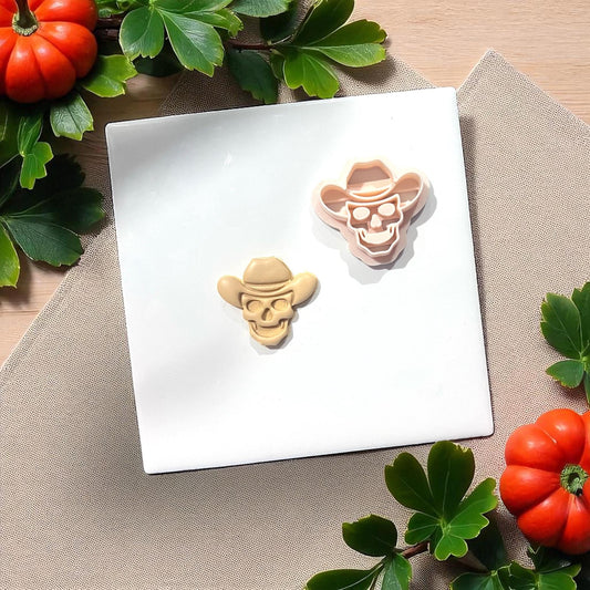 Cowboy skull cutter with clay piece on white tile with greenery