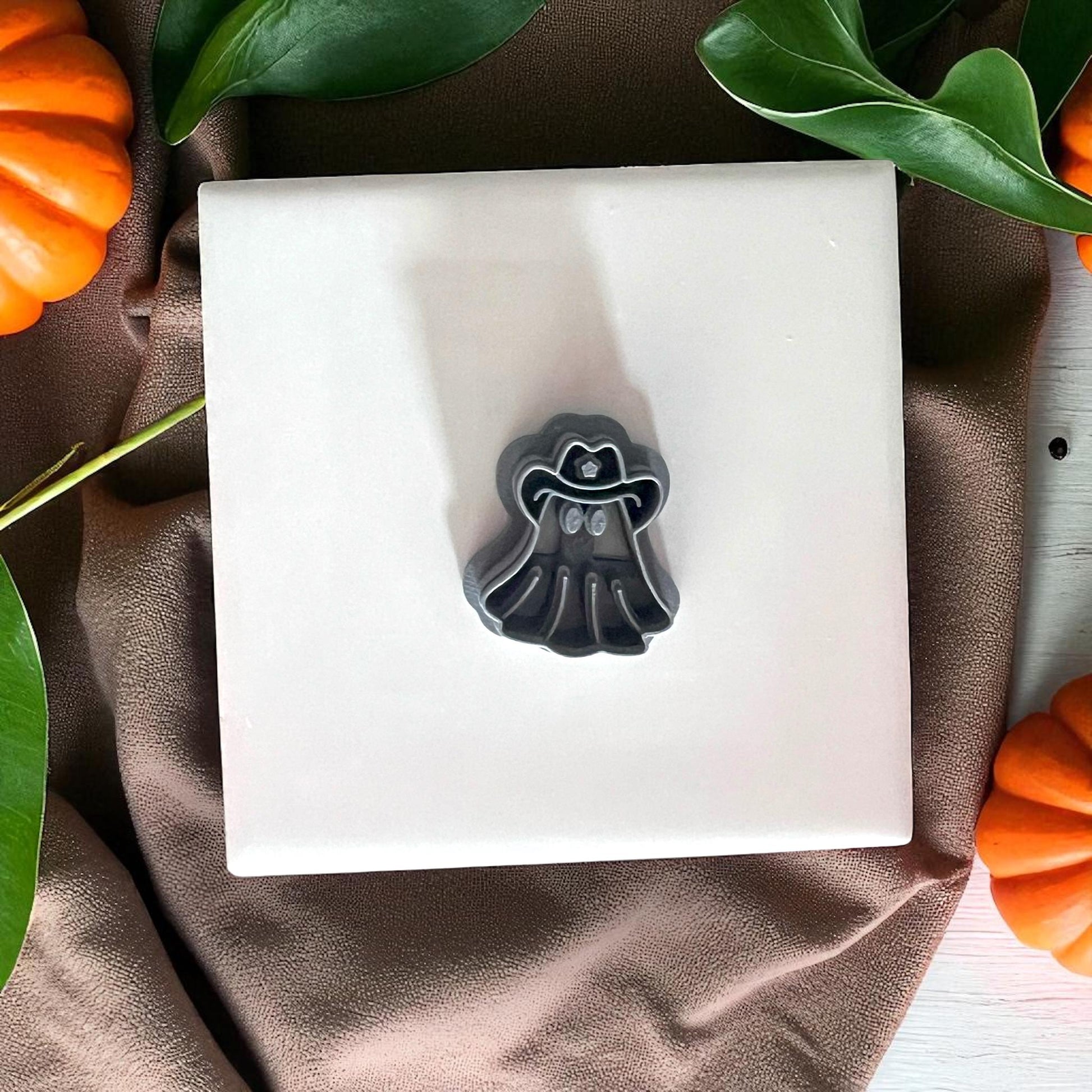 Cowboy ghost clay cutter on white tile with pumpkins