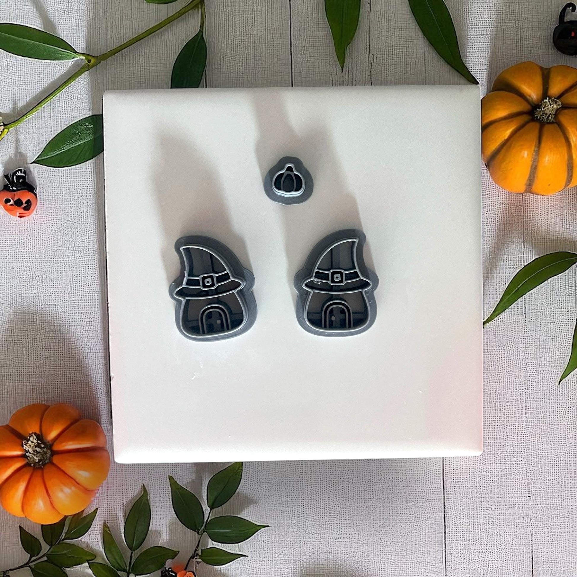 Witch house clay cutters with pumpkin cutter on white tile