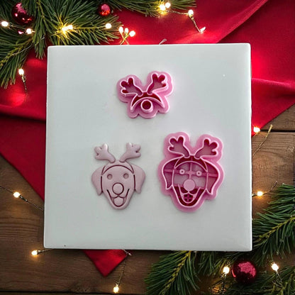 Labrador dog with reindeer antlers clay imprint and cutters displayed on white tile with Christmas lights