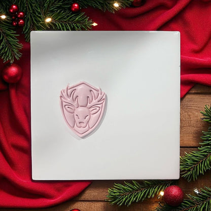 Reindeer clay imprint on white tile with holiday greenery