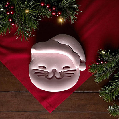 Large clay imprint of Santa cat with holiday greenery and red fabric
