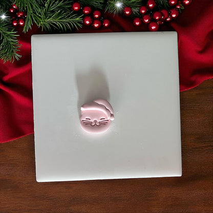 Small Santa cat clay imprint on white tile with Christmas decor