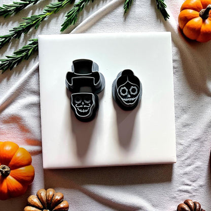Skull couple clay cutters in black with pumpkins and greenery