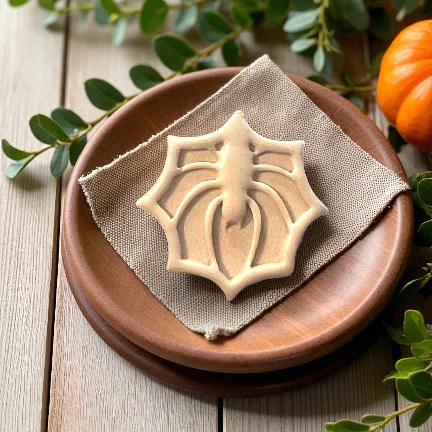 Large clay spider web impression on wooden plate with fabric