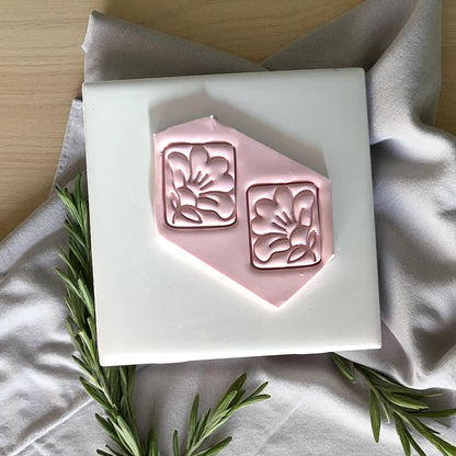 Square hibiscus flower clay imprints pressed into pink clay sheet