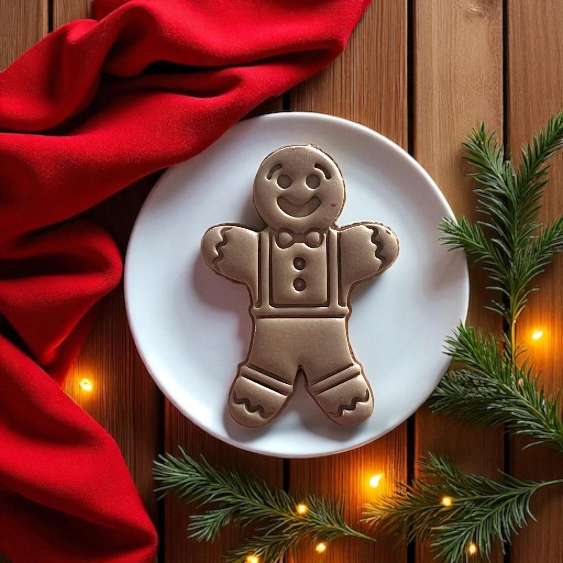 Gingerbread man clay design on white plate with Christmas lights
