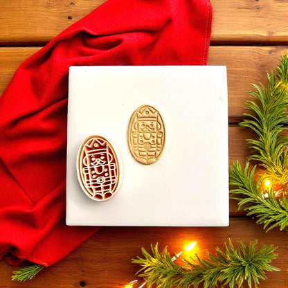 Nutcracker clay cutter and imprint side by side on red velvet background