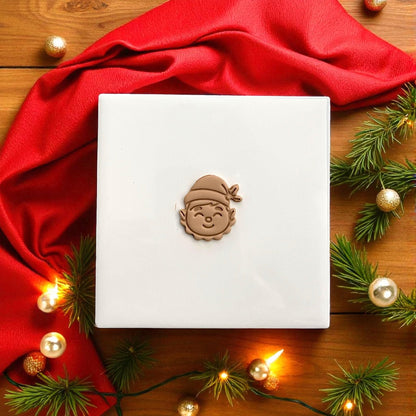 Christmas elf face clay design on white tile with lights and red scarf