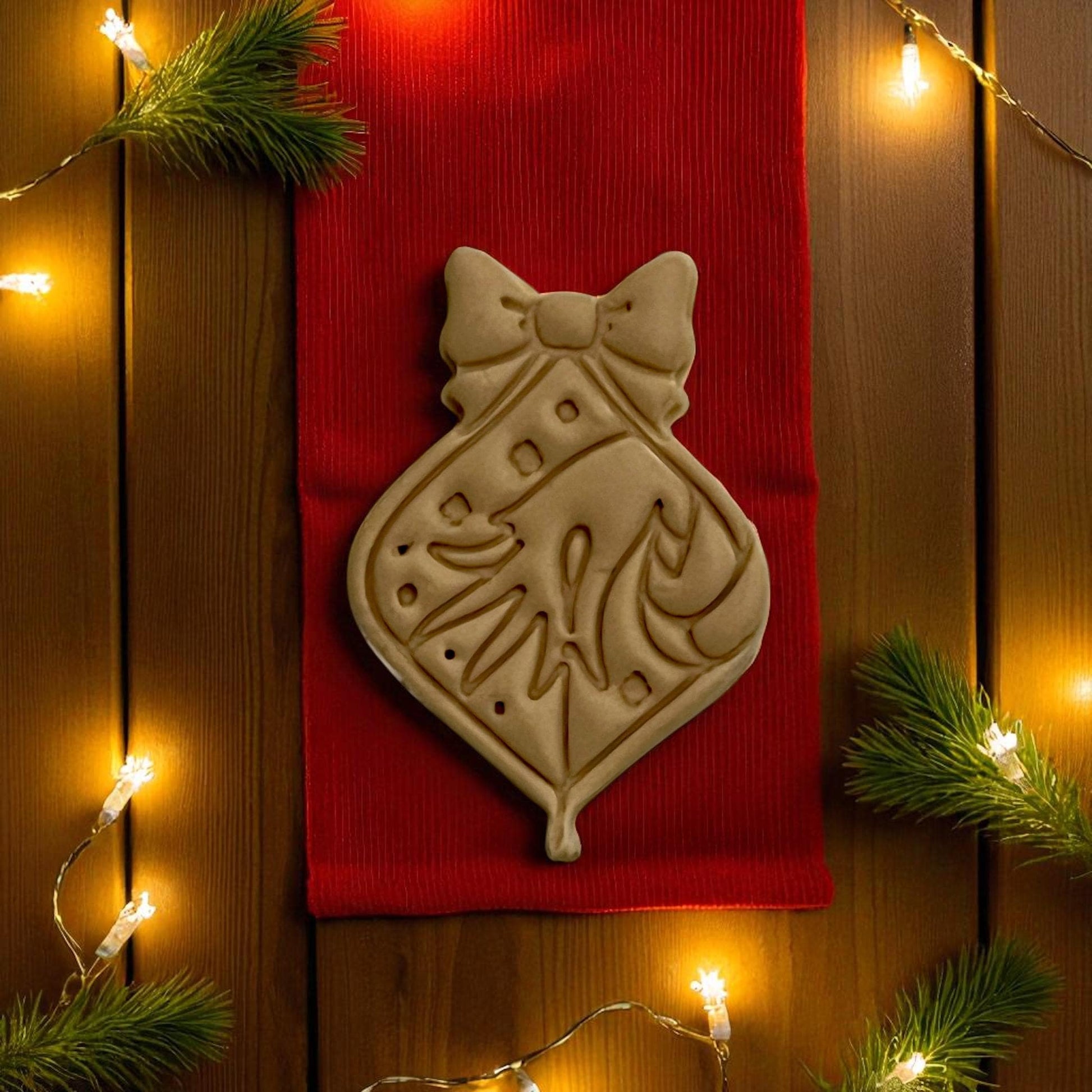 Close-up of Grinch ornament imprint showing hand and candy cane details