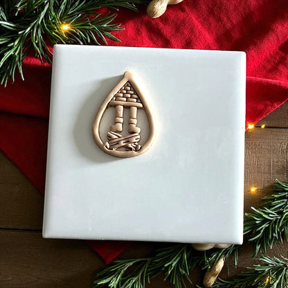 Santa boots fireplace clay design on white plate with red napkin and pine branches