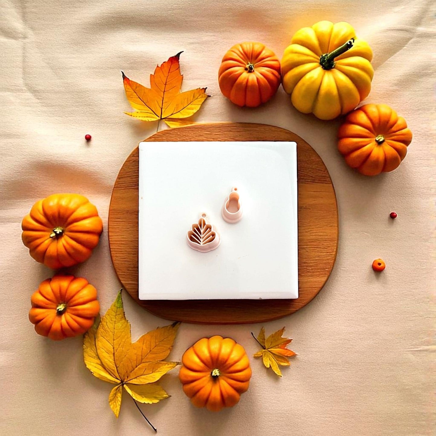 Polymer clay turkey cutter displayed on beige plate with pumpkins and fall leaves