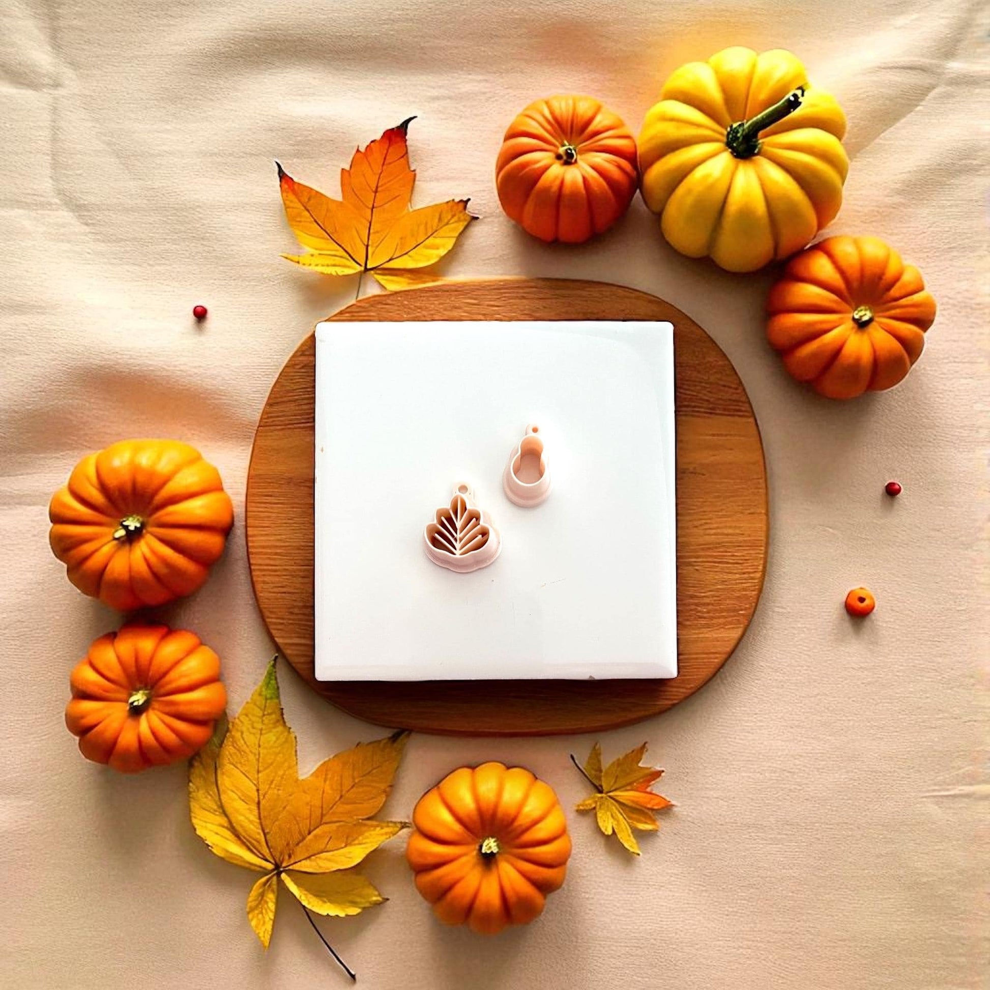 Polymer clay turkey cutter displayed on beige plate with pumpkins and fall leaves