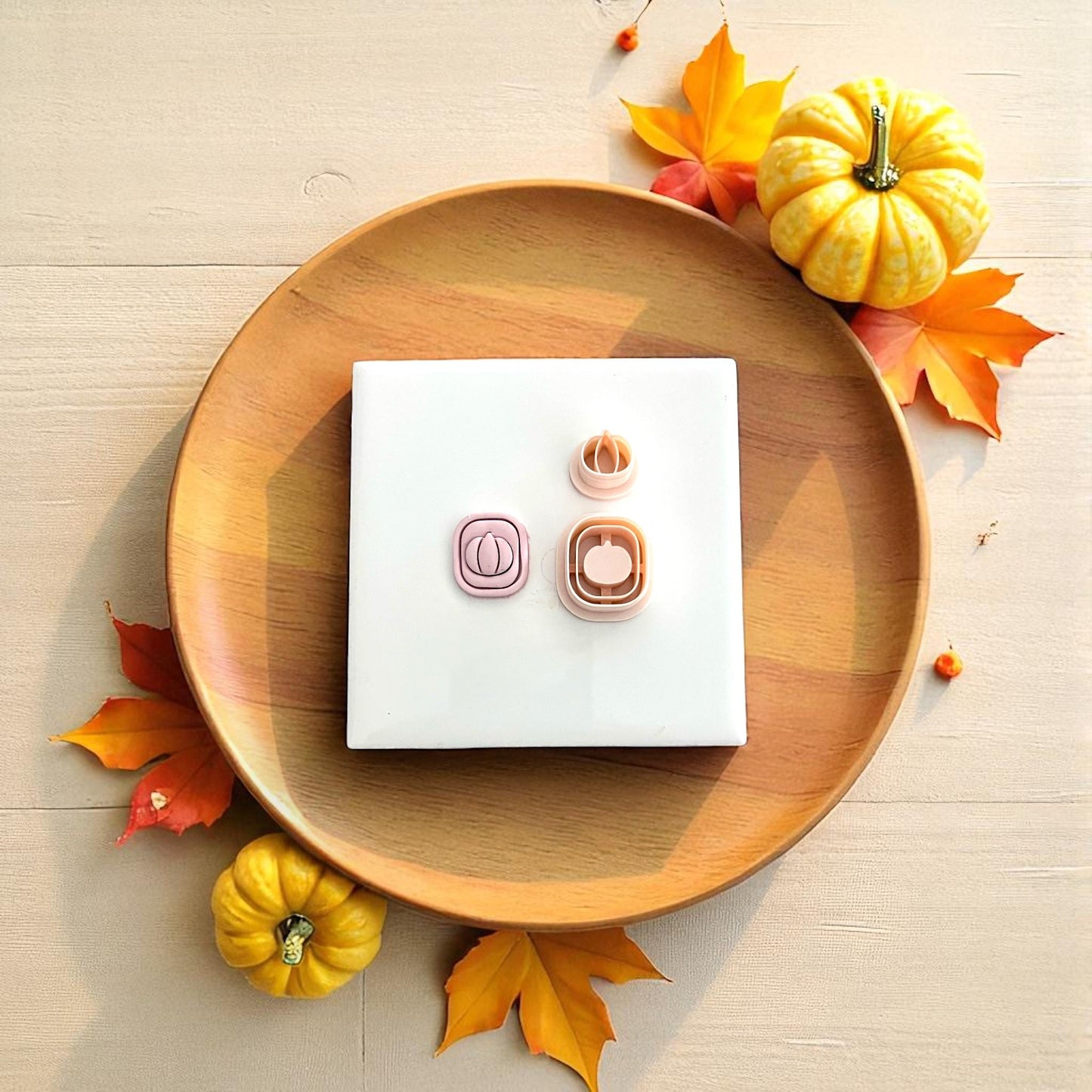 Pumpkin clay impression on white tile surrounded by fall decor