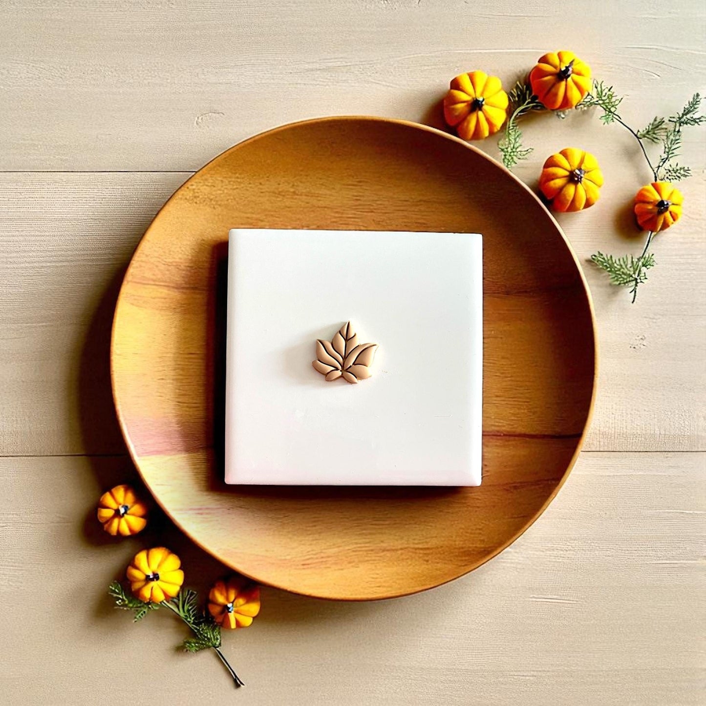 Fall leaf clay design on rustic wooden tray with pumpkins and autumn leaves