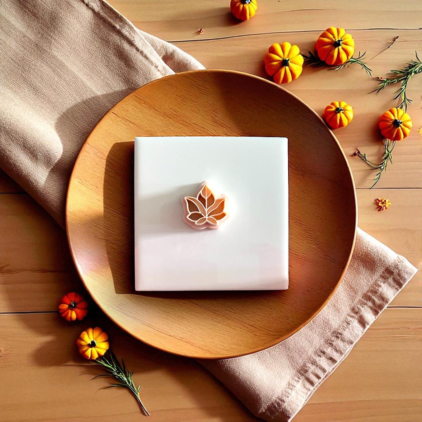 Fall leaf clay impression and cutter displayed together on plate with autumn decor