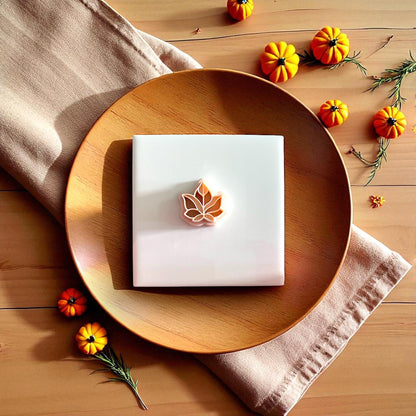 Fall leaf clay impression and cutter displayed together on plate with autumn decor