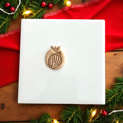 Shell clay cutter and clay impression displayed side by side with festive holiday lights