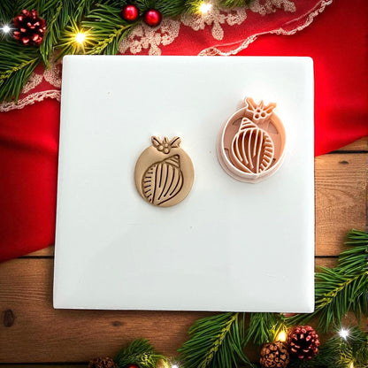 Shell clay impression displayed on white tile with red holiday ribbon and pine branches