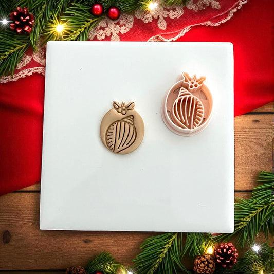 Shell clay impression displayed on white tile with red holiday ribbon and pine branches