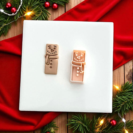 Snowman clay cutter and impression side by side on white tile with festive background