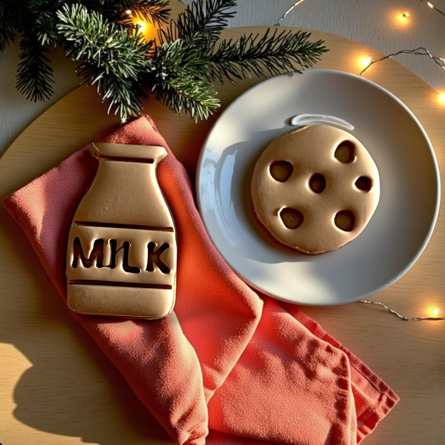 Close-up of milk and cookie clay shapes on a plate with holiday lights