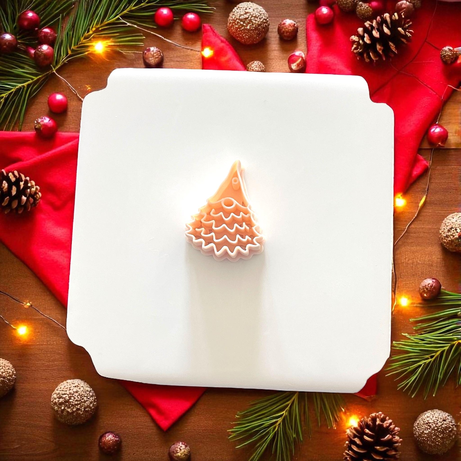 Christmas tree gnome polymer clay cutter on white tile with red fabric and pine accents
