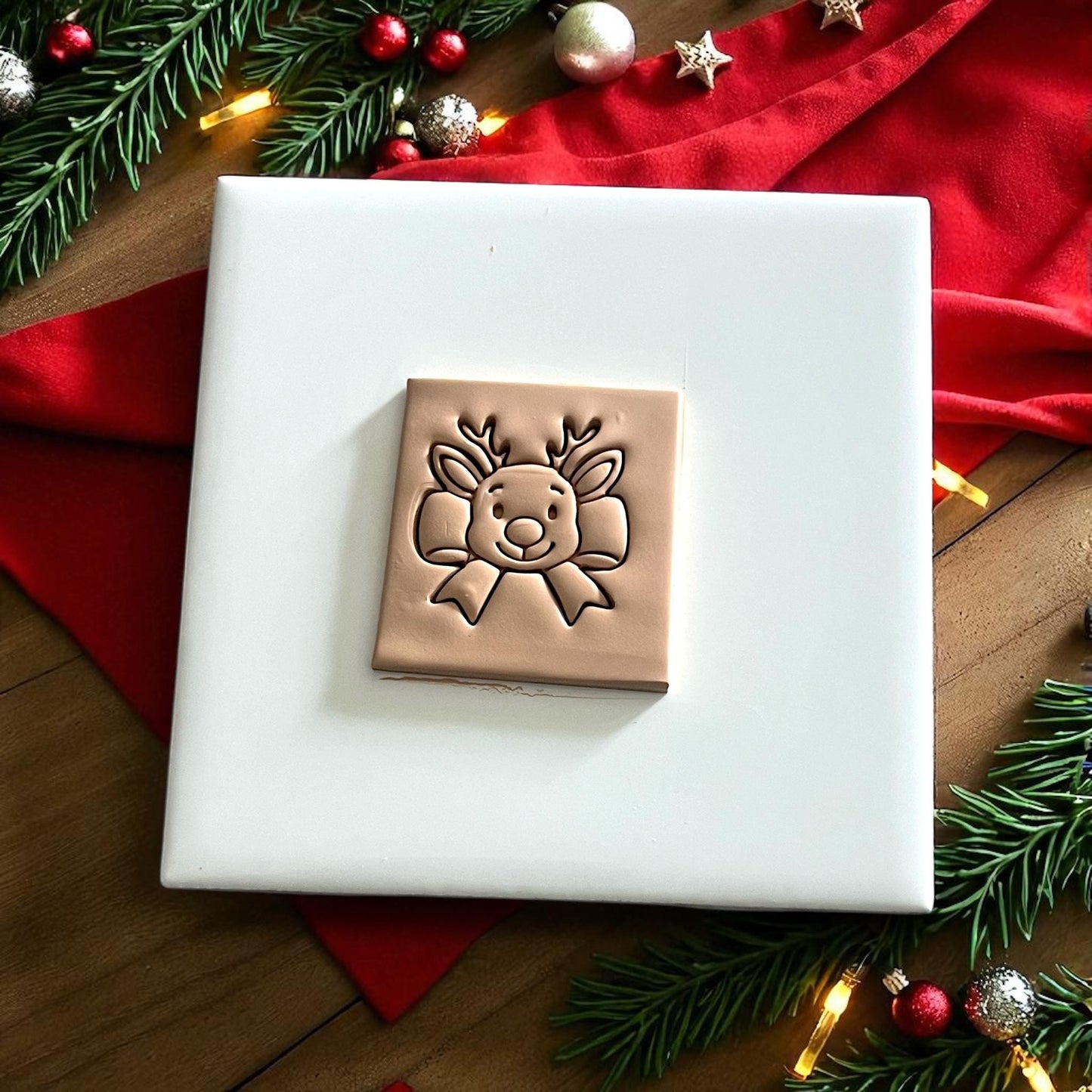 reindeer bow cutter and clay impression side by side on festive white tile