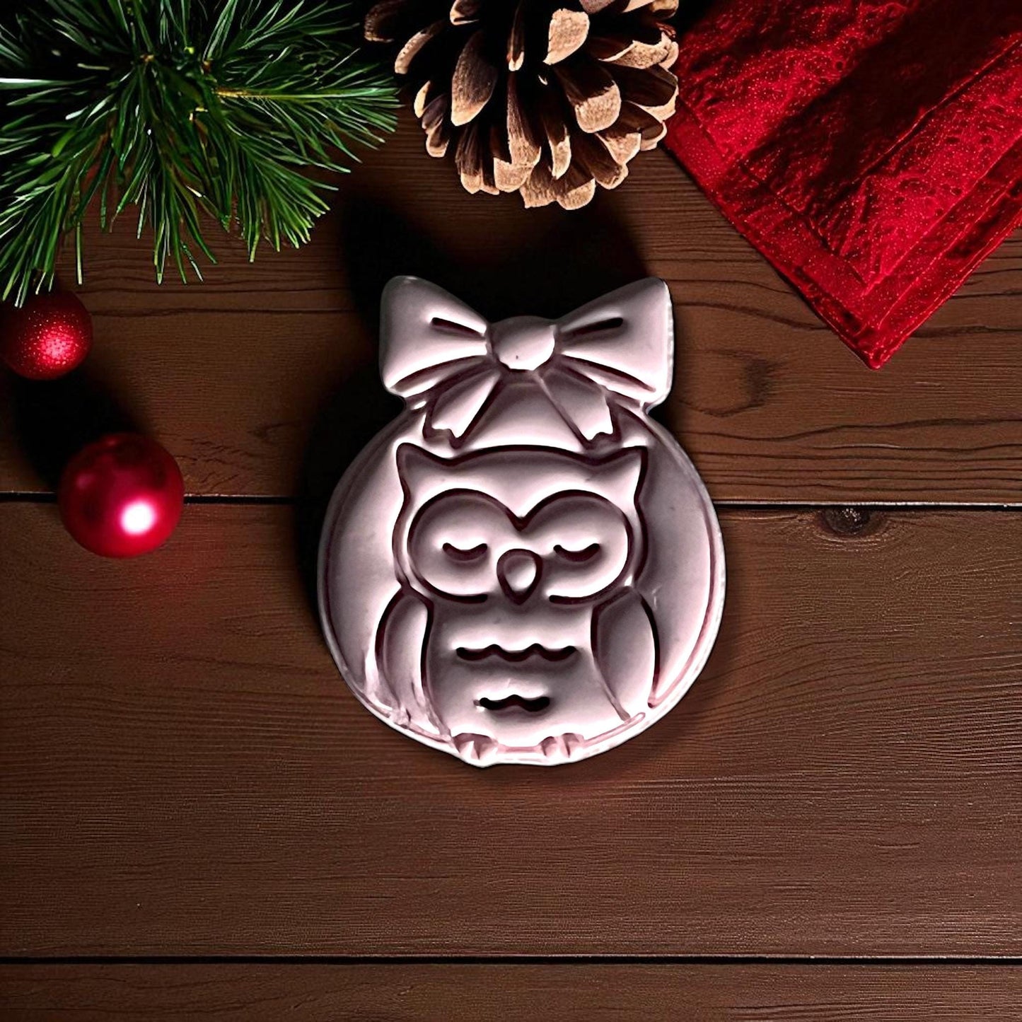 Close-up of owl ornament clay imprint with pinecone and greenery