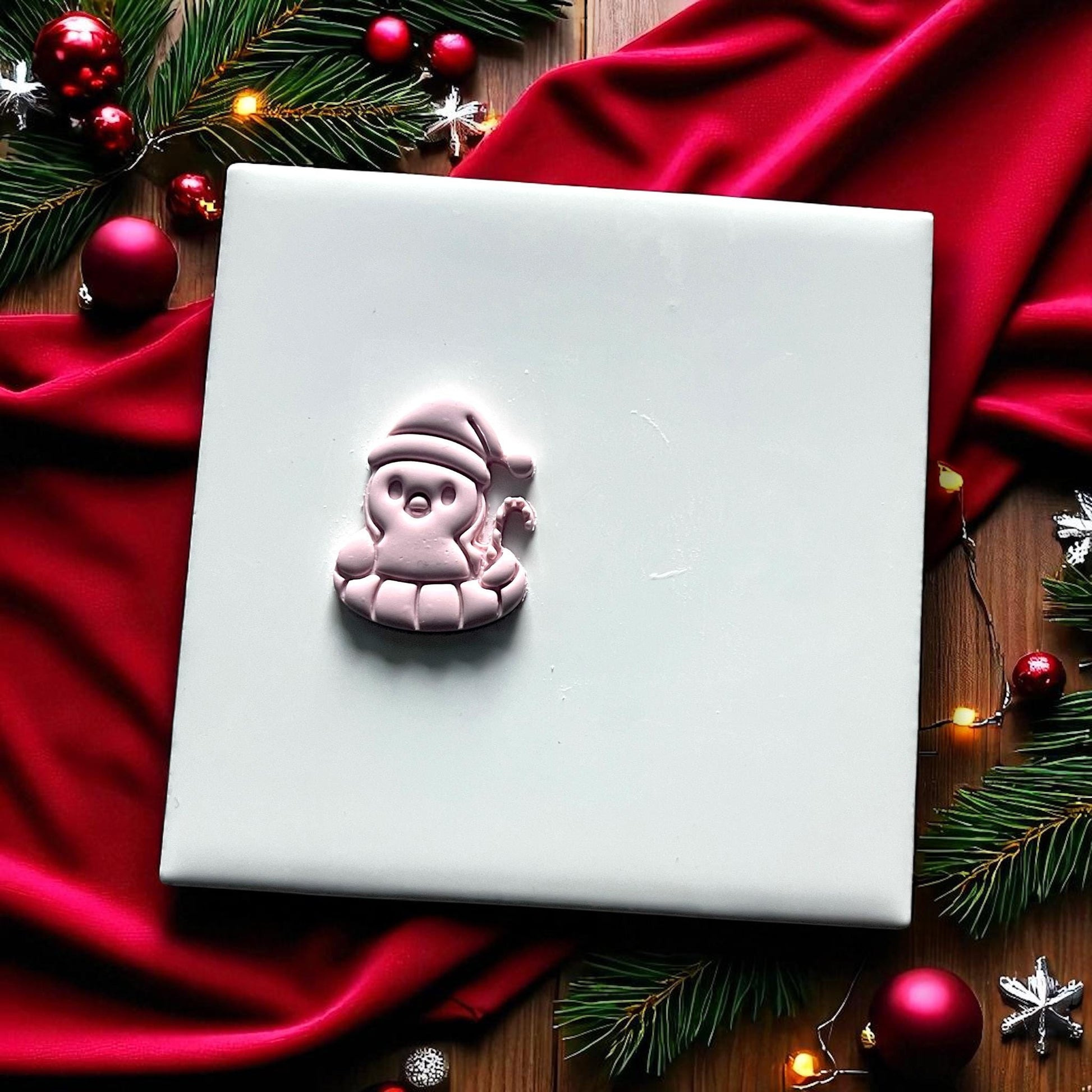 Penguin floatie Christmas clay imprint on white tile with red fabric
