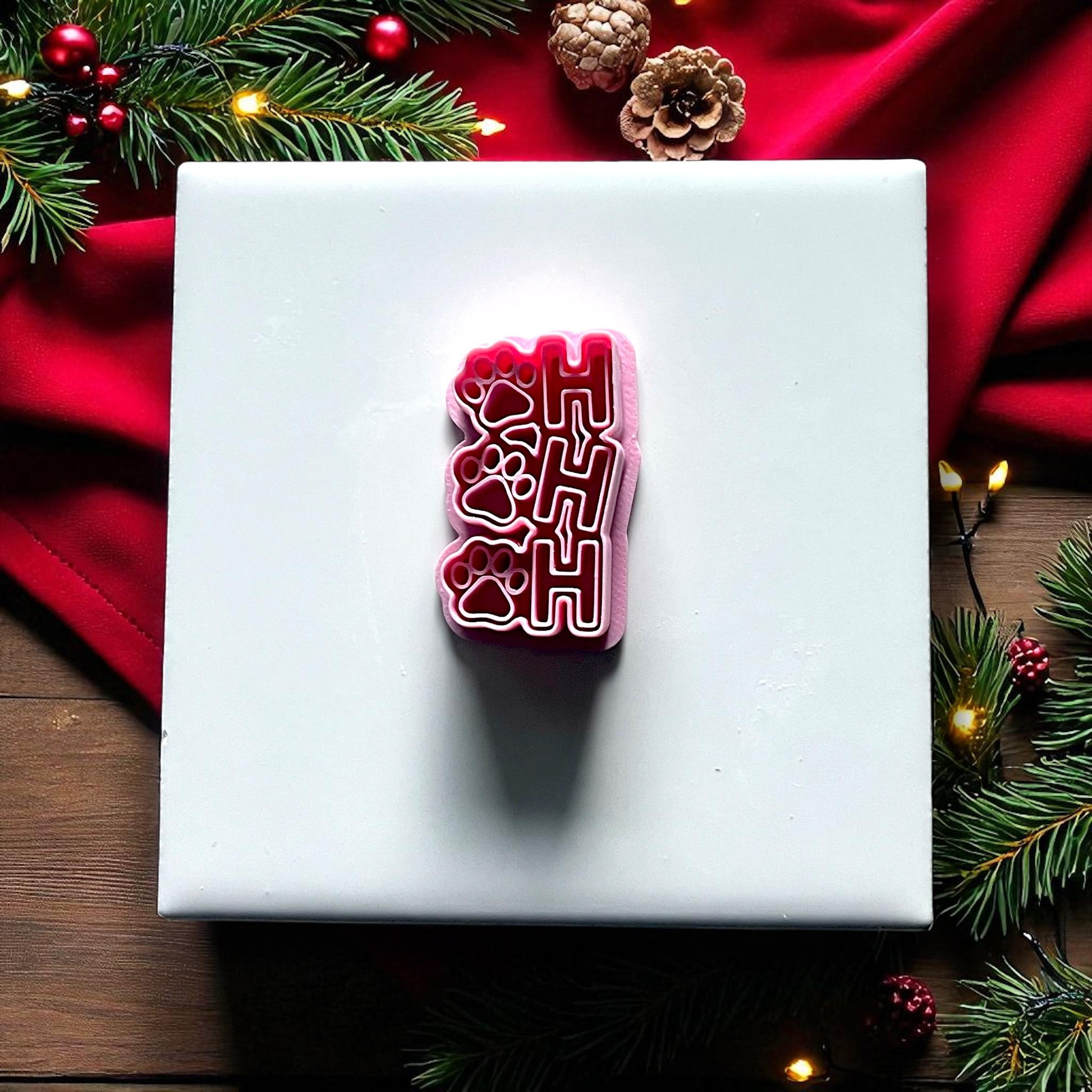 Red Ho Ho Ho paw print polymer clay cutter on white tile