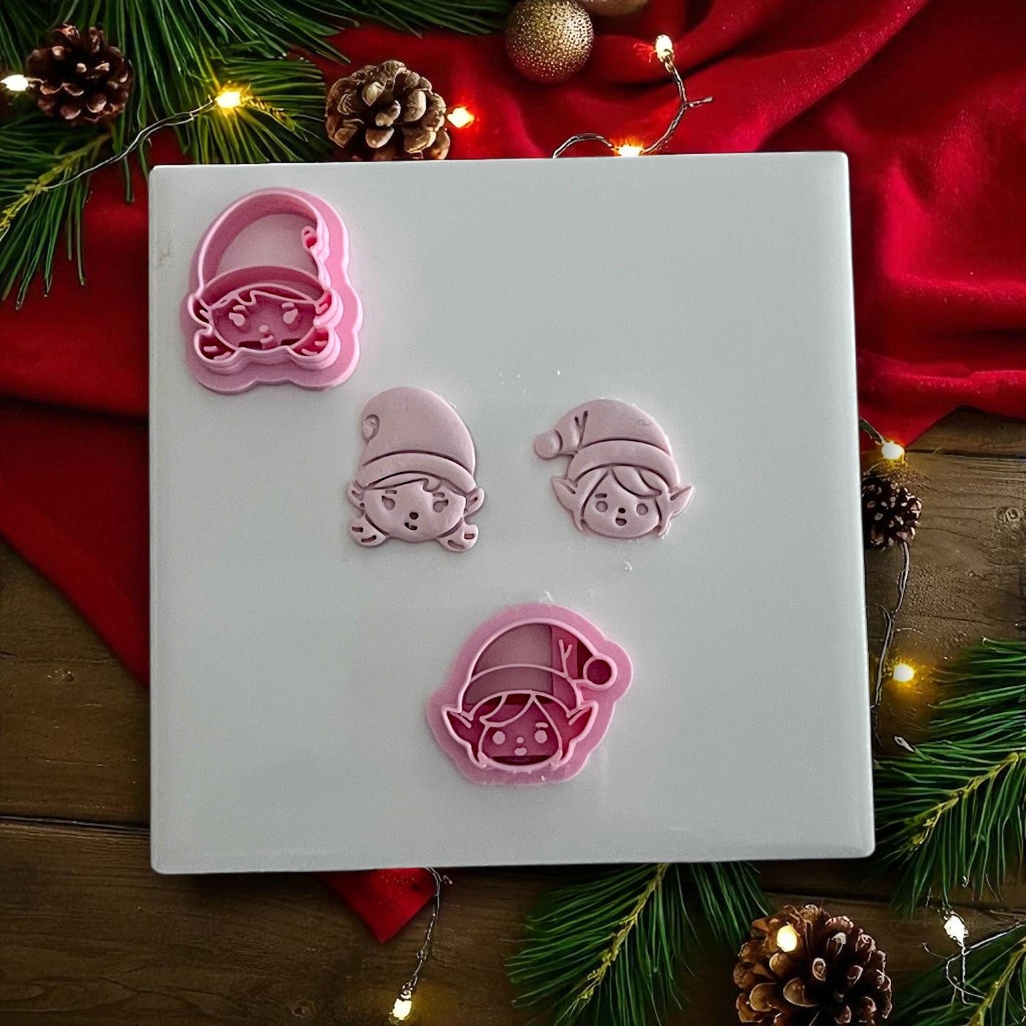 Elf boy and girl polymer clay cutters with clay imprints on white tile and holiday decor